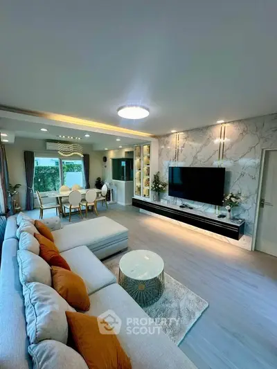 Luxurious modern living room with elegant decor and spacious layout, featuring a stylish dining area and large windows.