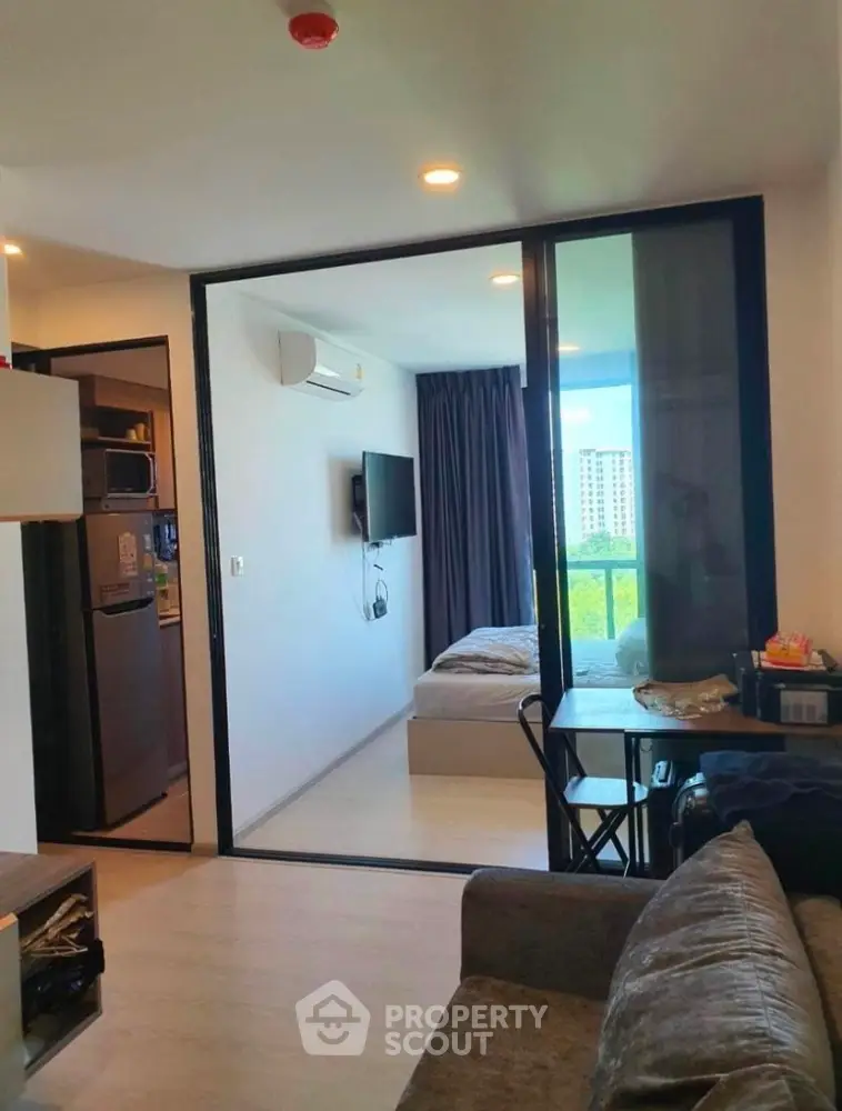 Modern studio apartment with sleek furniture and a seamless transition from a cozy living area to a peaceful bedroom space, boasting natural light and a smart layout.