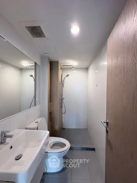 Modern bathroom with sleek fixtures and walk-in shower in a contemporary apartment.