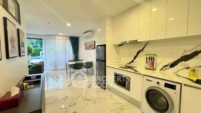 Modern kitchen with marble flooring, sleek appliances, and open layout leading to dining area.