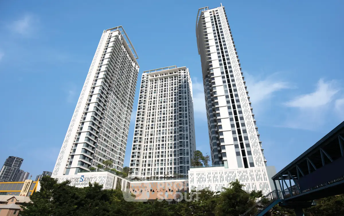 Stunning modern high-rise residential towers against a clear blue sky, showcasing urban luxury living.