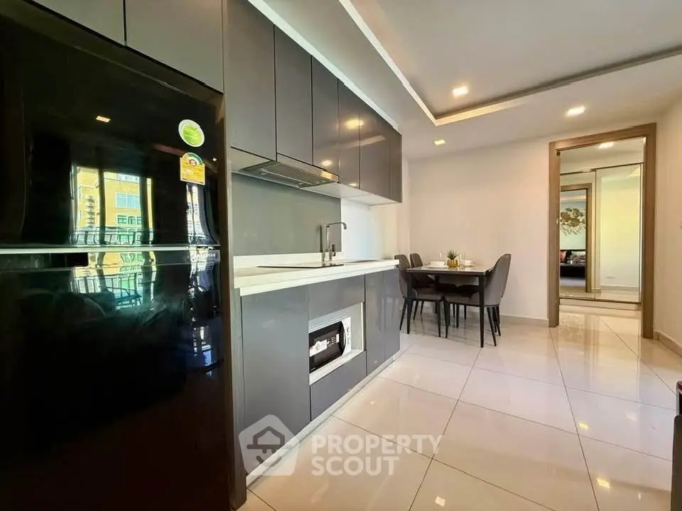 Modern kitchen with sleek cabinetry and dining area in open layout apartment