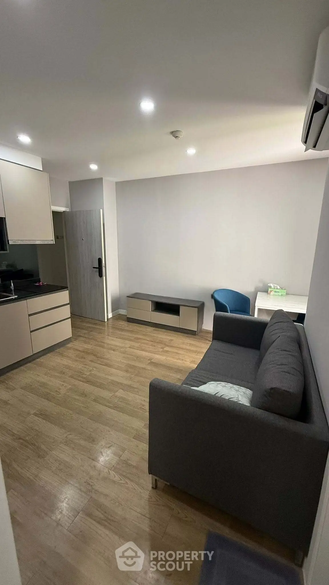 Modern living room with sleek furniture and open kitchen layout, perfect for urban living.