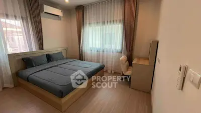 Modern bedroom with sleek design, featuring a comfortable bed and stylish desk area.