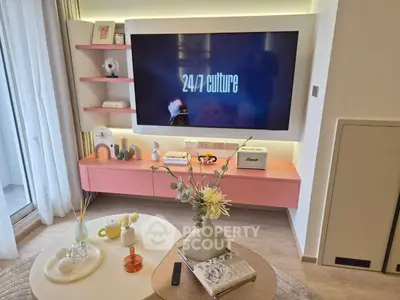 Modern living room with large TV, stylish decor, and balcony access