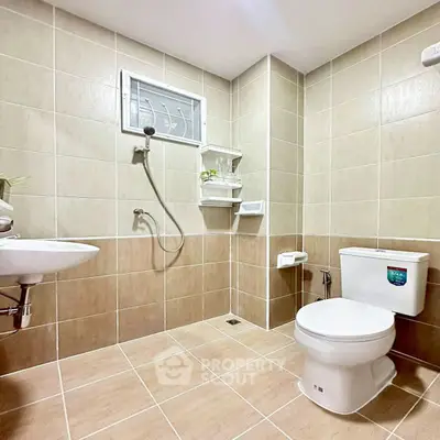 Modern bathroom with beige tiles and sleek fixtures