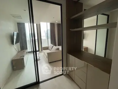 Modern apartment with glass door leading to a cozy living room and balcony view.