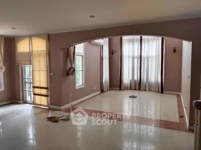 Spacious empty living room with large windows and elegant curtains