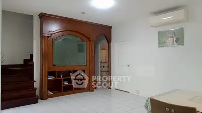 Spacious living area with elegant wooden cabinetry and modern air conditioning unit.