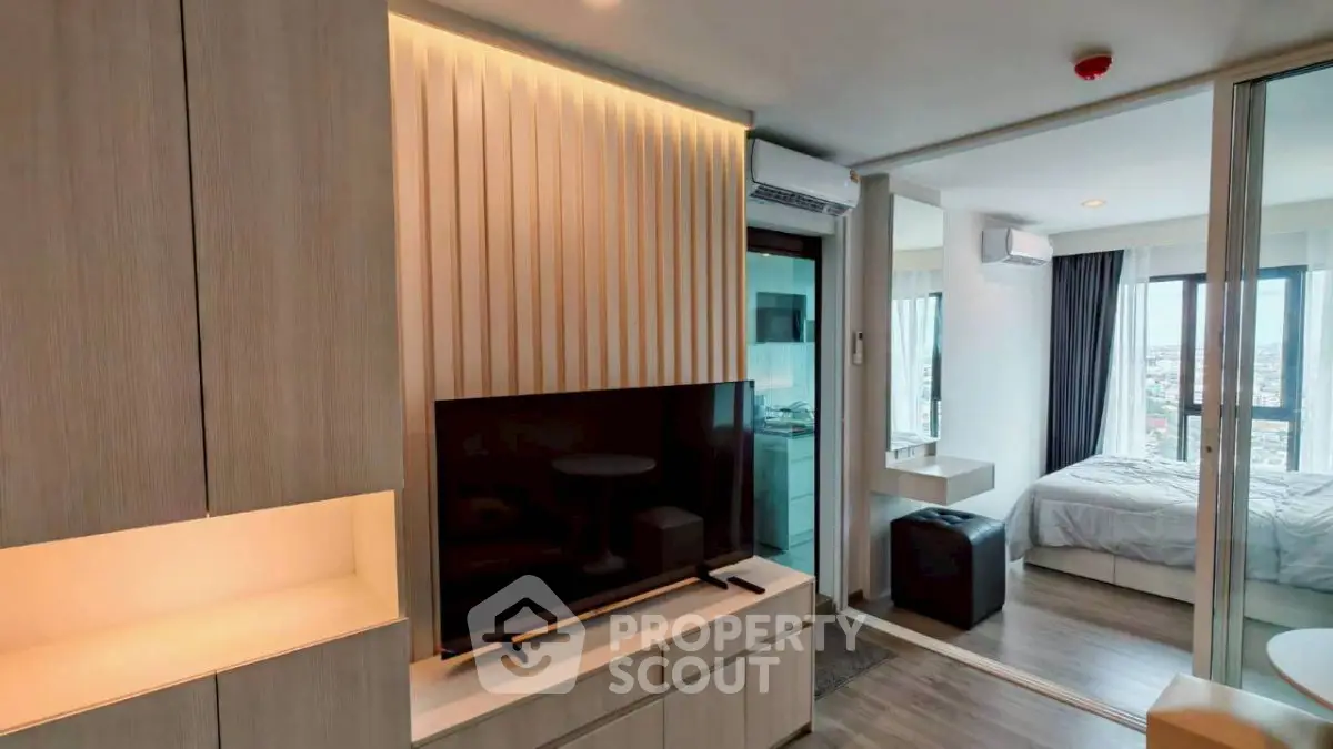 Modern apartment interior with open layout, featuring a cozy living area and a stylish bedroom with city views.