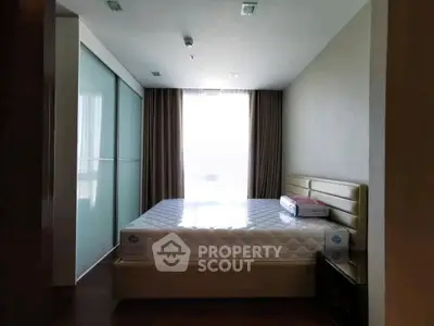 Modern bedroom with large window and stylish furnishings in a contemporary apartment.