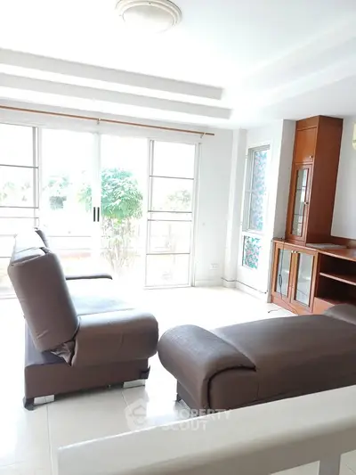 Bright and spacious living room with modern furniture and large windows offering natural light.