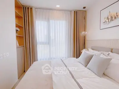 Elegant bedroom with large window and modern decor, perfect for relaxation.