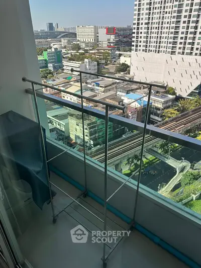 High-rise balcony with cityscape view and drying rack, perfect for urban living.