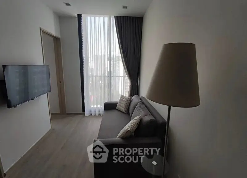 Modern living room with floor-to-ceiling window and sleek decor