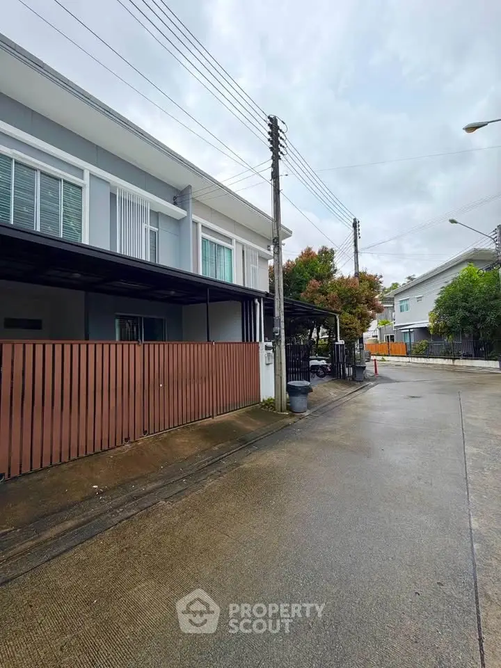 Modern townhouse exterior with sleek design and spacious driveway in a serene neighborhood.