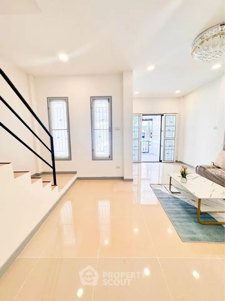 Spacious modern living room with elegant staircase and natural light