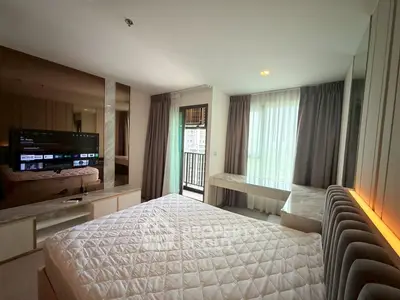 Modern bedroom with balcony view and stylish decor in a high-rise apartment.