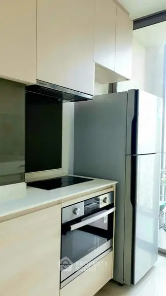 Modern kitchen with sleek appliances and ample natural light