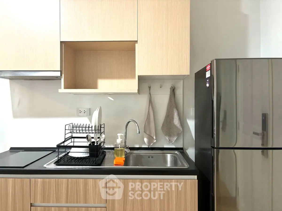 Modern kitchen with sleek cabinets and stainless steel fridge, ideal for urban living.