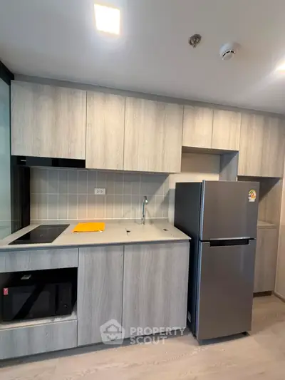 Modern kitchen with sleek cabinetry and stainless steel appliances in a contemporary apartment.