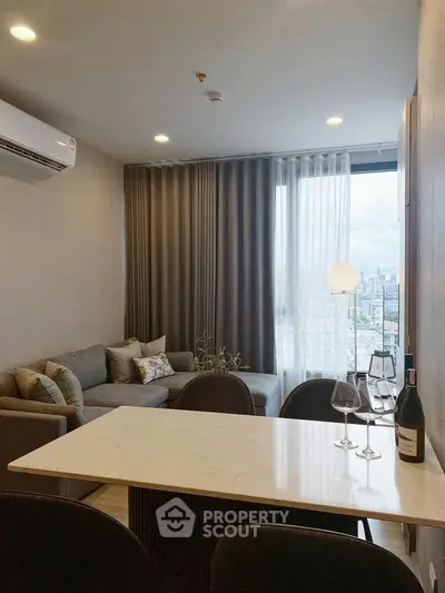 Modern living room with city view, featuring elegant decor and cozy seating area.