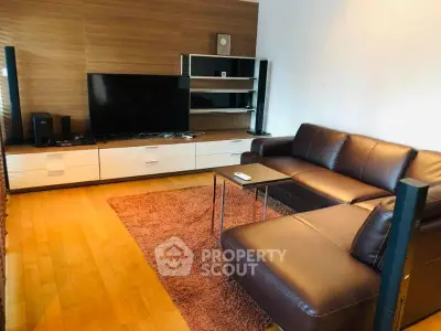 Modern living room with sleek leather sofa and entertainment center, perfect for relaxation and entertainment.