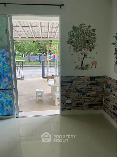 Charming home entrance with artistic wall decor and outdoor seating area.
