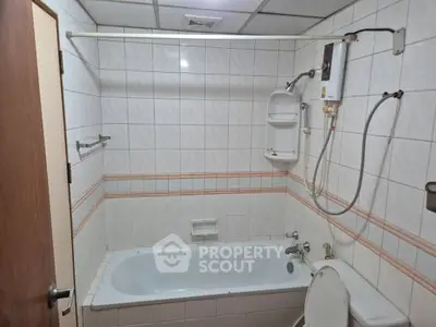 Compact bathroom with bathtub and water heater, tiled walls and ceiling.
