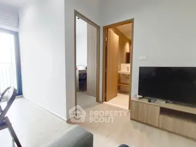 Modern apartment interior with open living area and bathroom view