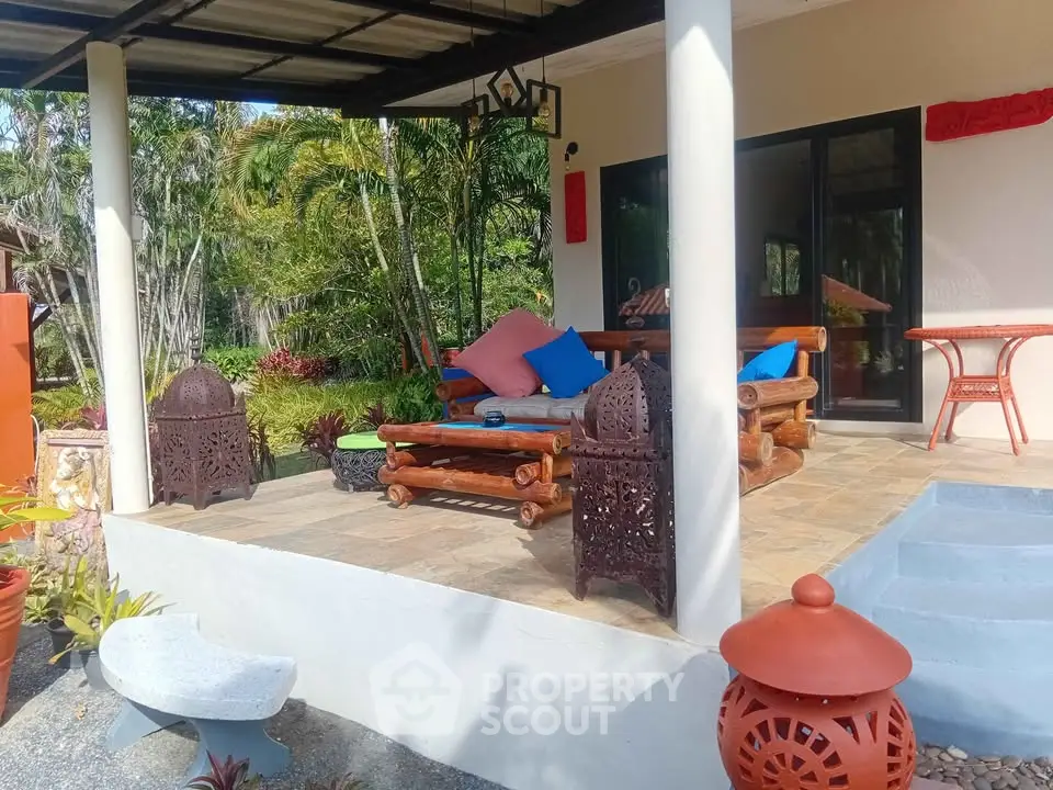 Charming patio with rustic furniture and lush garden view, perfect for outdoor relaxation.