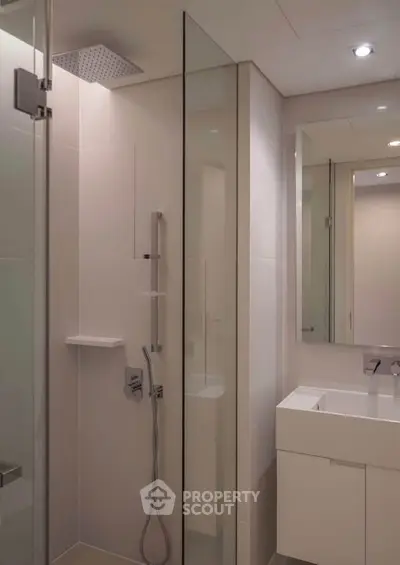 Modern bathroom with sleek shower and vanity in contemporary apartment.