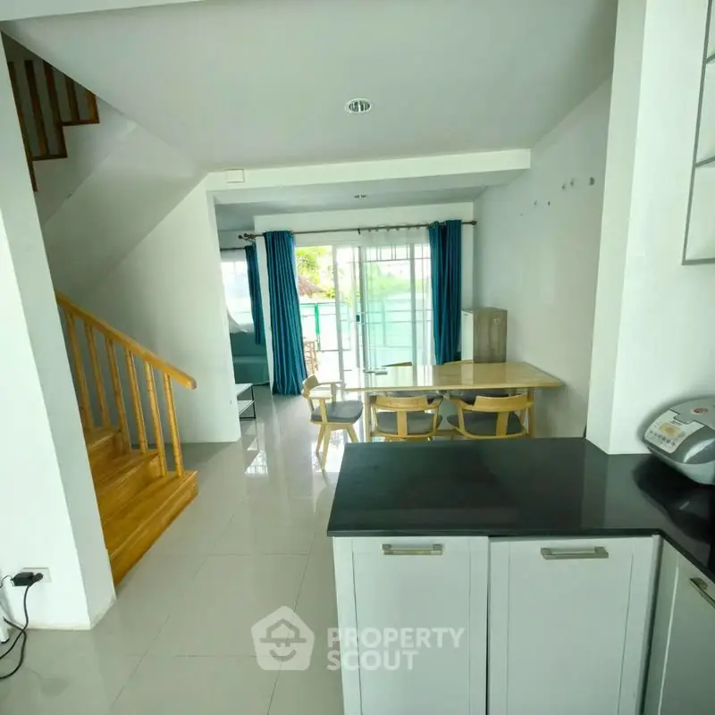 Spacious open-plan living area with modern kitchen and dining space, featuring large windows and natural light.