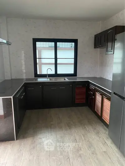 Modern kitchen with sleek black cabinetry and stainless steel appliances