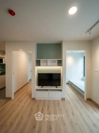 Modern living room with built-in TV unit and wooden flooring