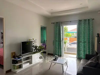Bright living room with modern decor and access to outdoor patio, featuring a sleek TV setup.