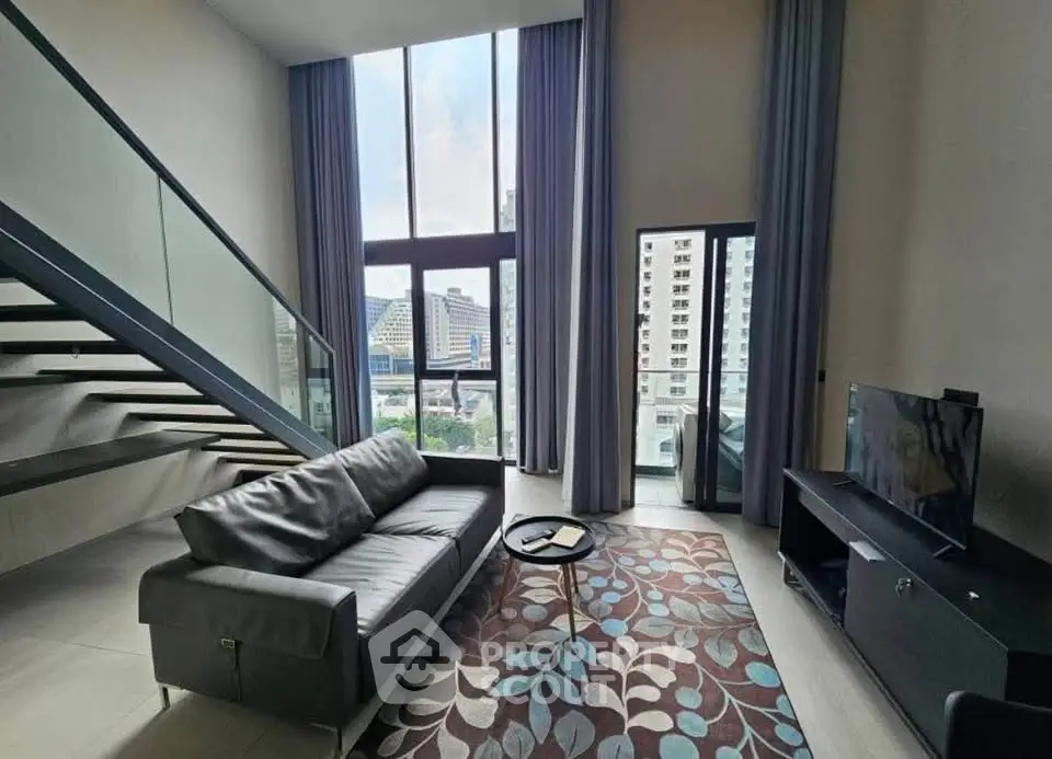 Spacious modern living room with high ceilings and large windows offering city views.