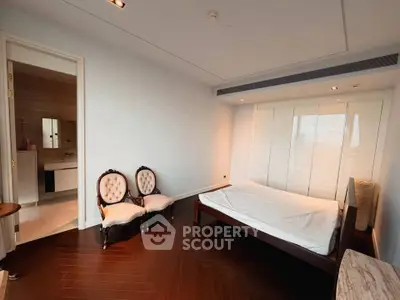 Spacious bedroom with elegant chairs and modern ensuite bathroom