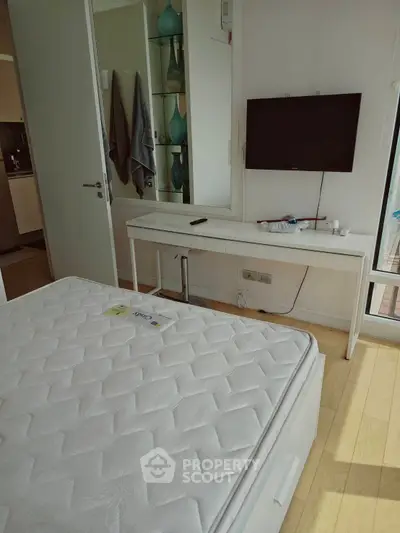 Modern bedroom with sleek design and wall-mounted TV, perfect for urban living.