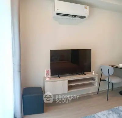 Modern living room with wall-mounted TV and air conditioning unit, stylish and cozy interior design.