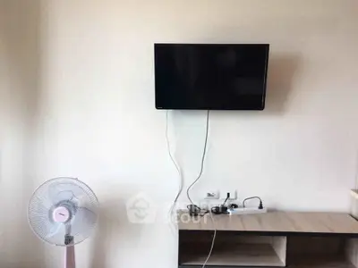 Modern living room with wall-mounted TV and sleek wooden cabinet