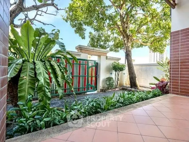 Charming garden entrance with lush greenery and tiled pathway