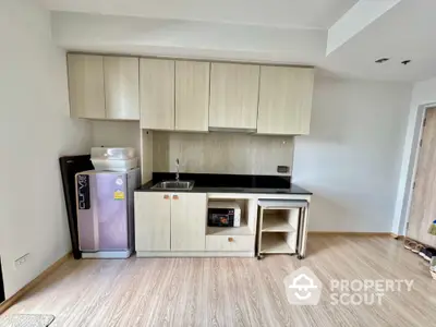 Modern kitchen with sleek cabinetry and compact fridge in a stylish apartment