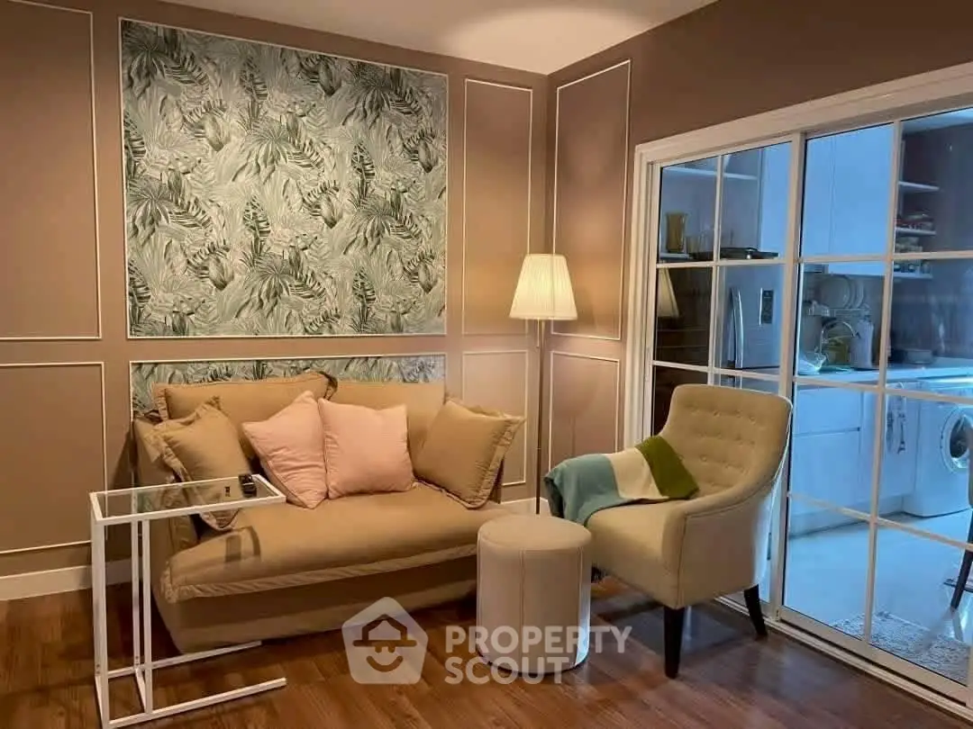Charming living room with elegant decor and view into modern kitchen