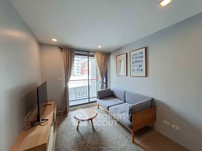 Modern living room with balcony view, featuring sleek furniture and natural light.