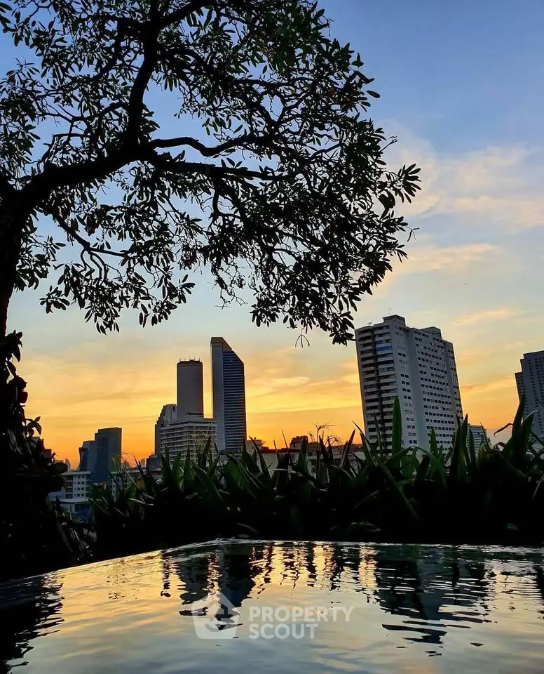 Stunning city skyline view from a serene rooftop pool at sunset, perfect for urban living enthusiasts.