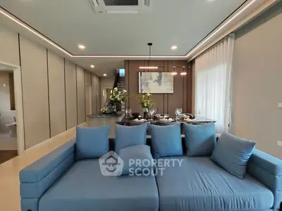 Luxurious open-plan living room with modern blue sofa and elegant dining area