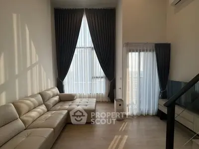 Spacious modern living room with high ceilings and elegant curtains