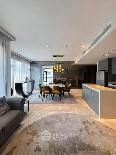 Luxurious open-plan living and dining area with modern furnishings and elegant lighting.