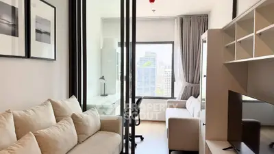 Modern living room with glass partition and city view, featuring cozy sofa and stylish decor.